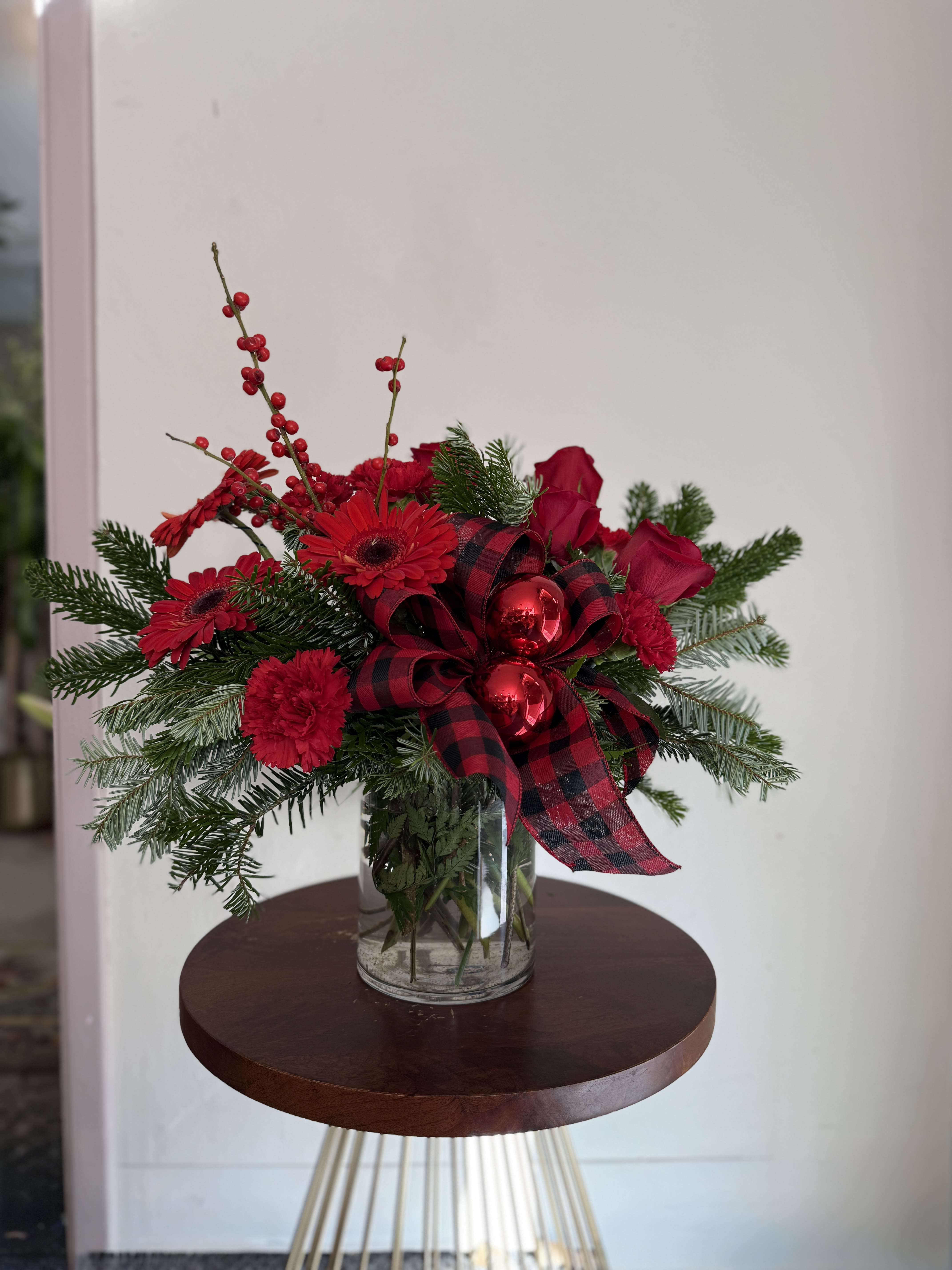 Christmas Cyclinder - Varietys of red blooms including roses, carnations, and christmas berries. Bow and ornarments included.