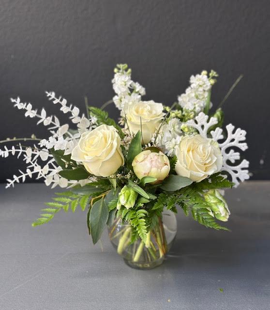 The Frosty - A beautiful winter time arrangement, designed using all white florals, roses, peonies, stock, and parrot tulips, with a fun snowflake add on and lush textural foliage.
