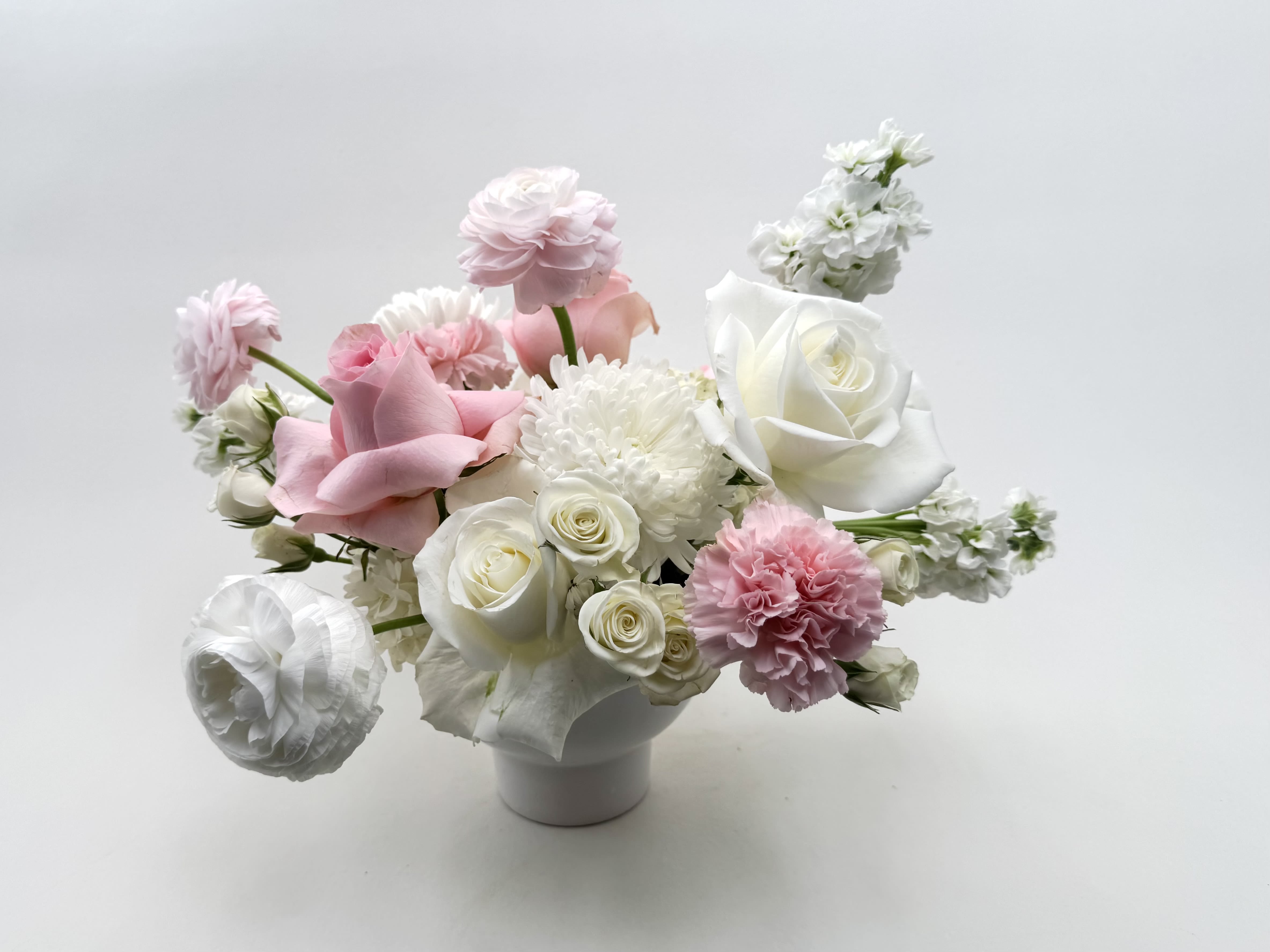 Aphrodite  - Yes Goddess! Send the goddess in your life our beautiful Aphrodite flower arrangement! Soft pink and white flowers are arranged gorgeously in a white ceramic contemporary vase.   Delivery Info- We make all of our deliveries after 1pm every day. If the weather is very cold, we prefer not to leave the flowers outside. Please let the recipient know that they should expect delivery.