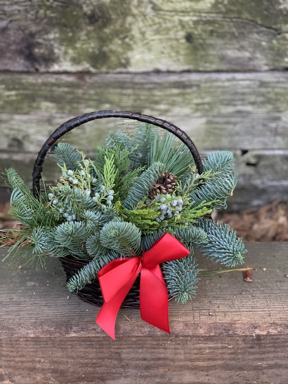 Holiday Mixed Greens Basket - Sweet basket filled with mixed evergreens effervescent of holiday Spirits.  Deluxe and premium upgrades available with roses