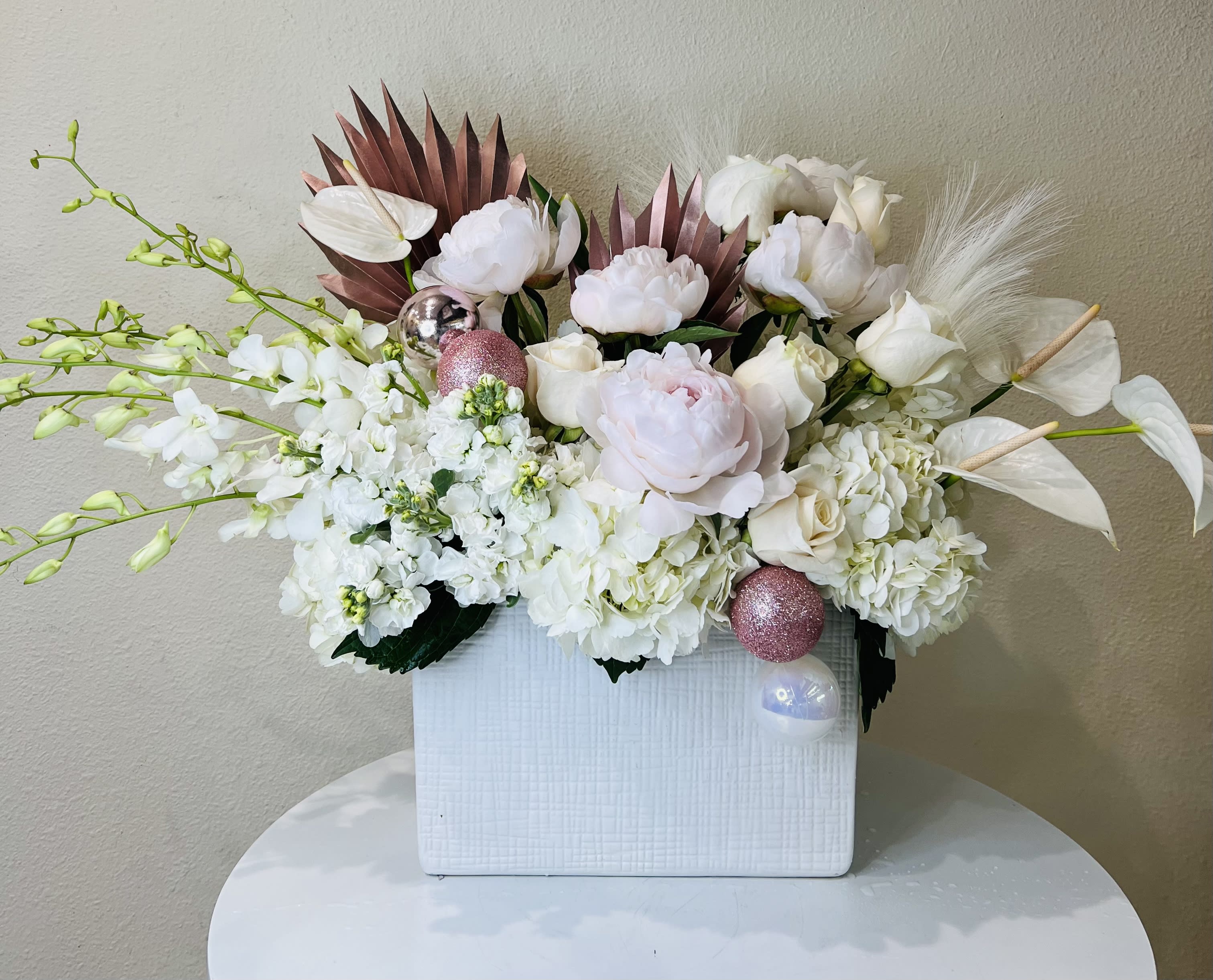 Blush Holiday Arrangement - Beautiful mixture of all white and blush flowers including Peonies, Orchids, Anthurium, Roses, Hydrangea with rose gold accents in white ceramic vase 