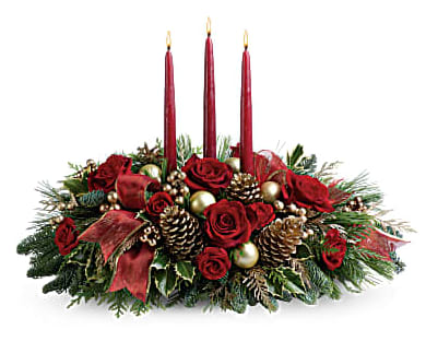 All Is Bright - All is calm, all is bright…well, at least we can promise the latter with this luminous arrangement! Gather family and friends together for a holiday meal around this traditional Christmas centerpiece featuring pinecones, holly, noble fir and Christmas candles. 'Tis the season to shine! A fresh centerpiece of holly, noble fir, white pine, flat cedar, roses and spray roses is decorated with golden berries, Christmas ornaments, pinecones and three red taper candles. A sheer, gold-edged organza ribbon adds to the opulence. 