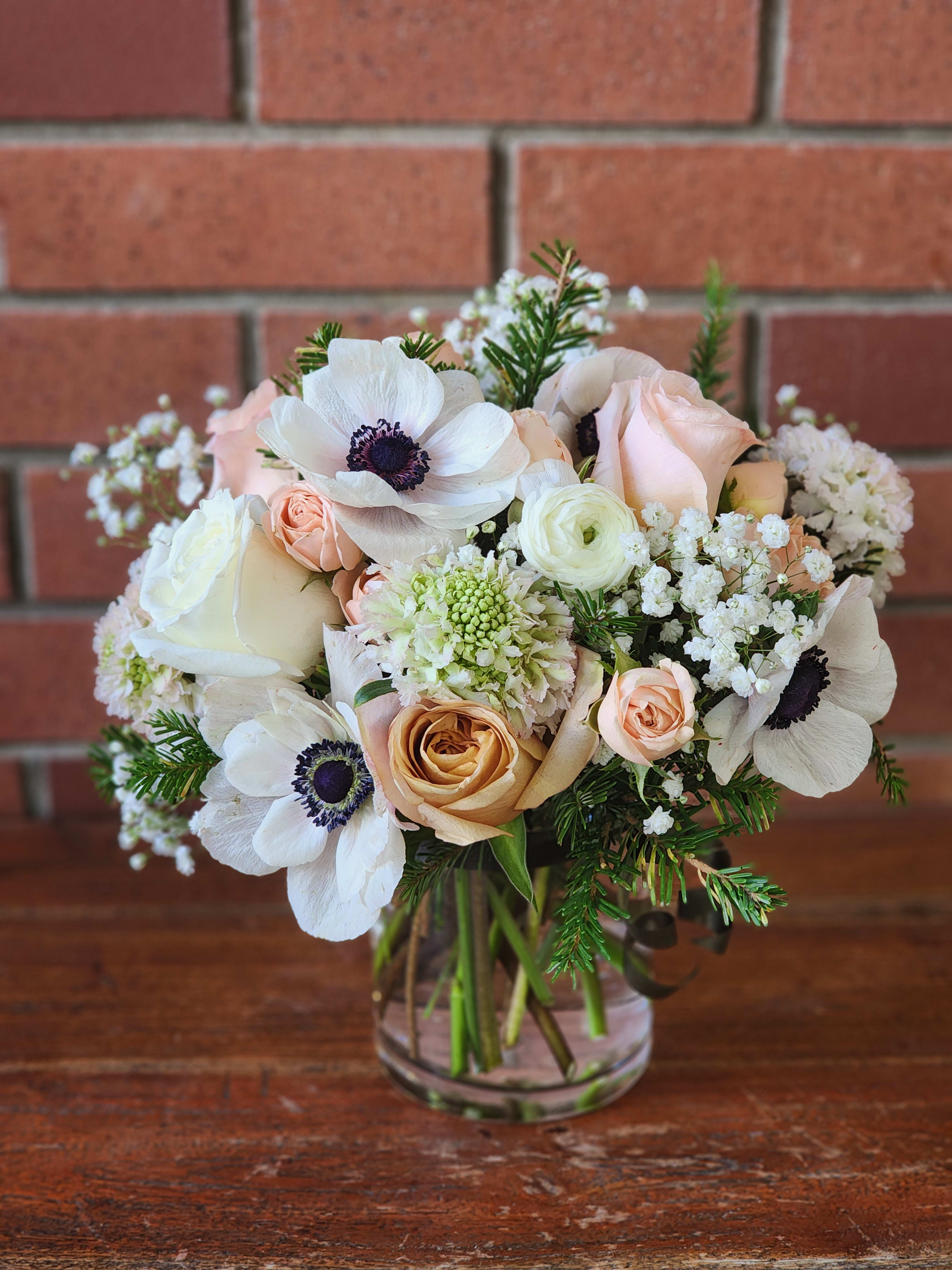 Blush Lush Bouquet  - Modern rectangular vase filled with evergreens, blush antique roses, scabiosa, ranunculus, baby's breath and anemones - accented with hunter green ribbons 
