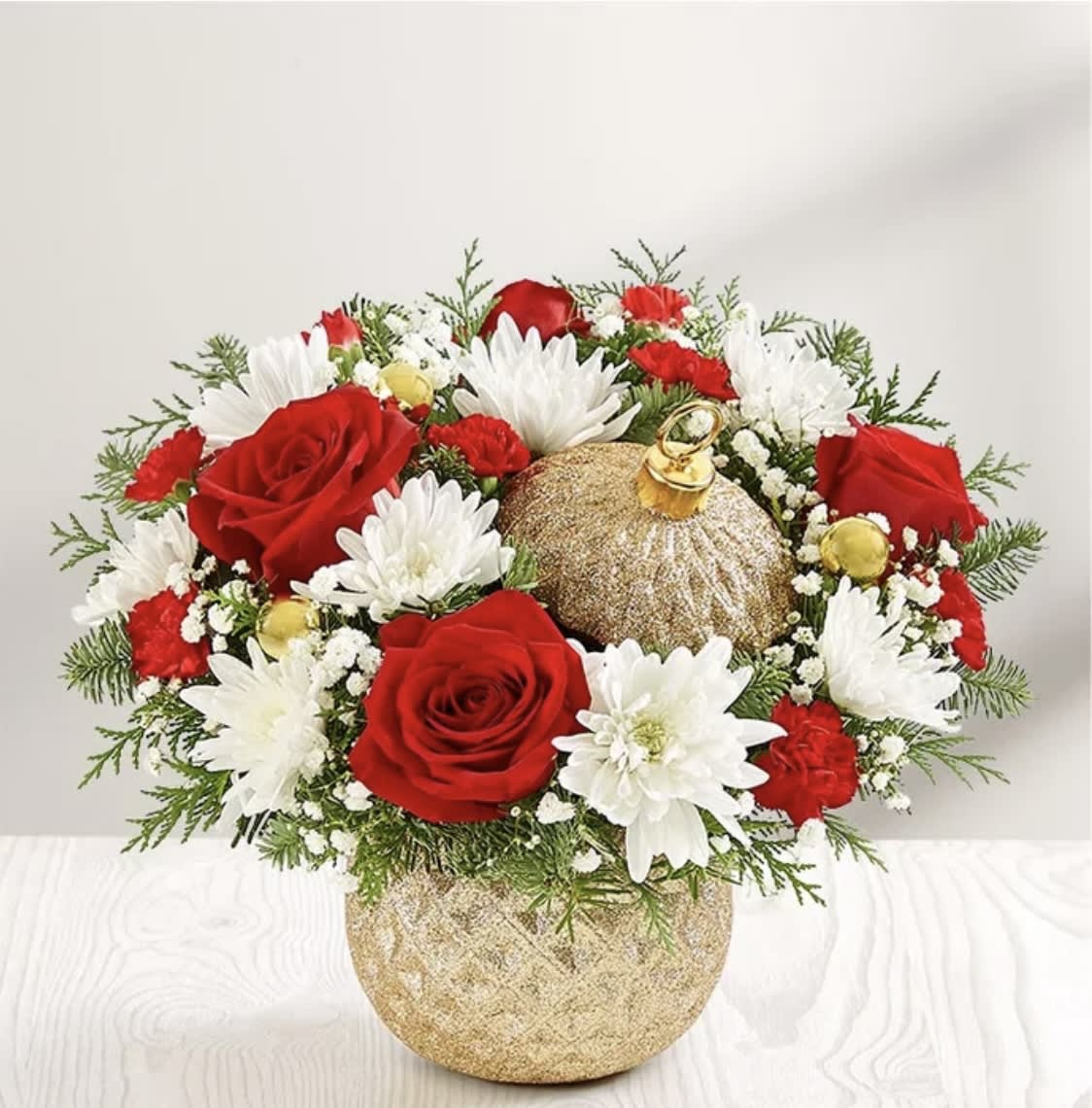 Holiday Ornament™ - Description EXCLUSIVE The signature beauty of the holiday season is captured in our limited-edition arrangement. Joyful red and white blooms are gathered with festive gold ball ornaments and arranged in our Glittering Gold Holiday Ornament™ container. With its diamond-embossed design, lavish gold glitter and matching lid, it’s a luxurious keepsake they’ll treasure for years to come.