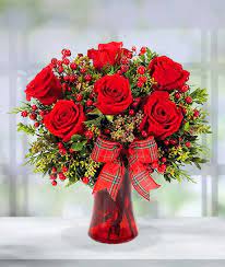 Holiday Kisses Bouquet - Feel the holiday spirit with our Holiday Kisses Bouquet! Adorned with bold red roses, red berries and winter greens, this festive arrangement creates a picturesque season's greetings! Bow design may vary.