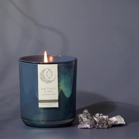 Amethyst &amp; Iris Soy Candle - Hand poured in California, our Amethyst &amp; Iris scented candle has a luxurious and relaxing scent that is crafted with a blend of beautiful botanicals and wood notes.  Centered around relaxation and wellbeing, the Amethyst &amp; Iris fragrance is inspired by the connection and love that Amethyst encourages, and the wisdom properties of Iris.