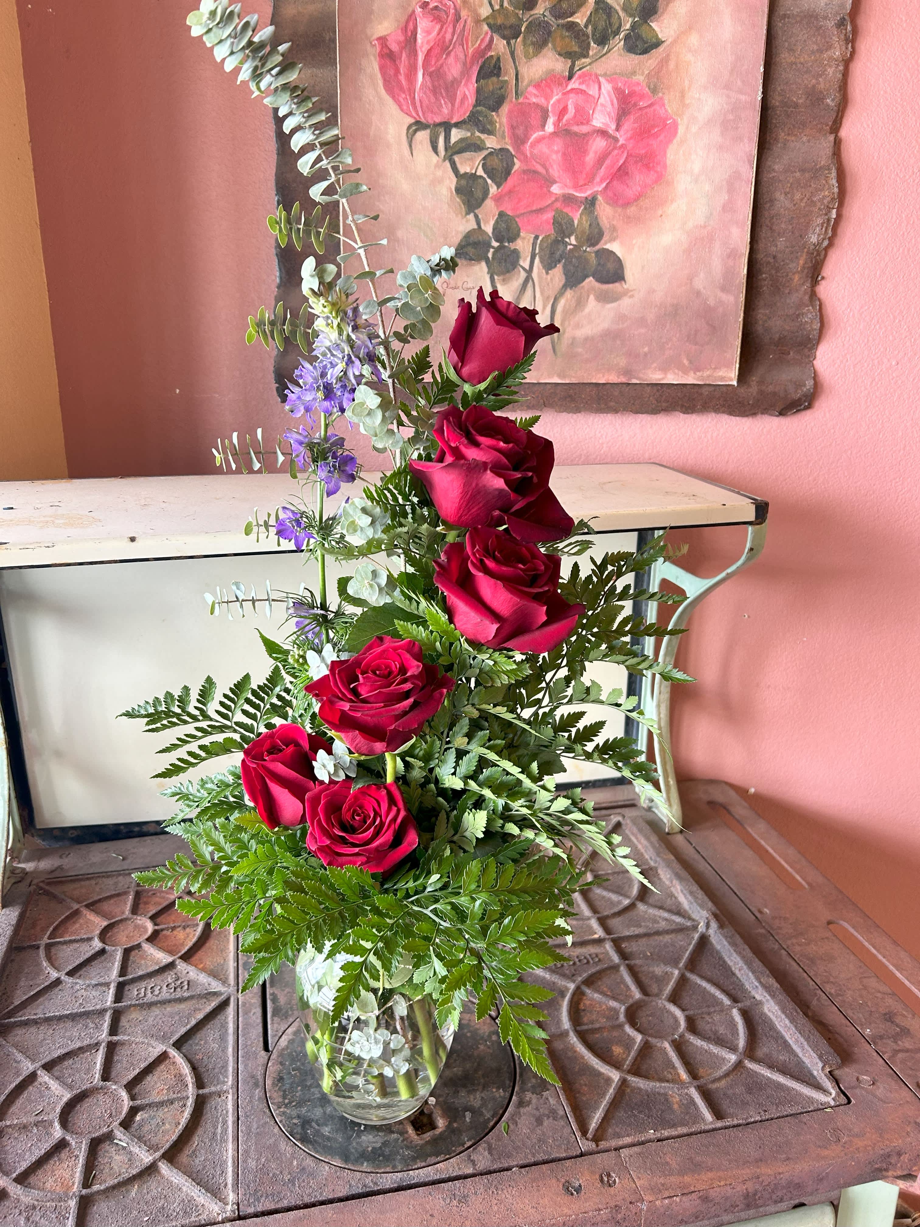 Tower of Love - Show her how high your love goes with this beautiful tower of roses. She will enjoy half dozen roses with standard, 9 rose with deluxe, and a loving tower of a full dozen to the heavens with premium. this is a one sided arrangement as shown.
