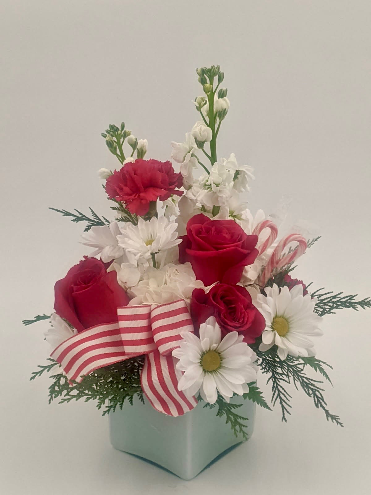 Peppermint Kiss - Sweet, festive and impossible to resist. Peppermint Kiss features a charming blend of red and white blooms inspired by the classic holiday candy cane featured with the peppermint candy itself! Designed to share and spread holiday spirit to your loved ones for a delightful gift and a beautiful centerpiece. 