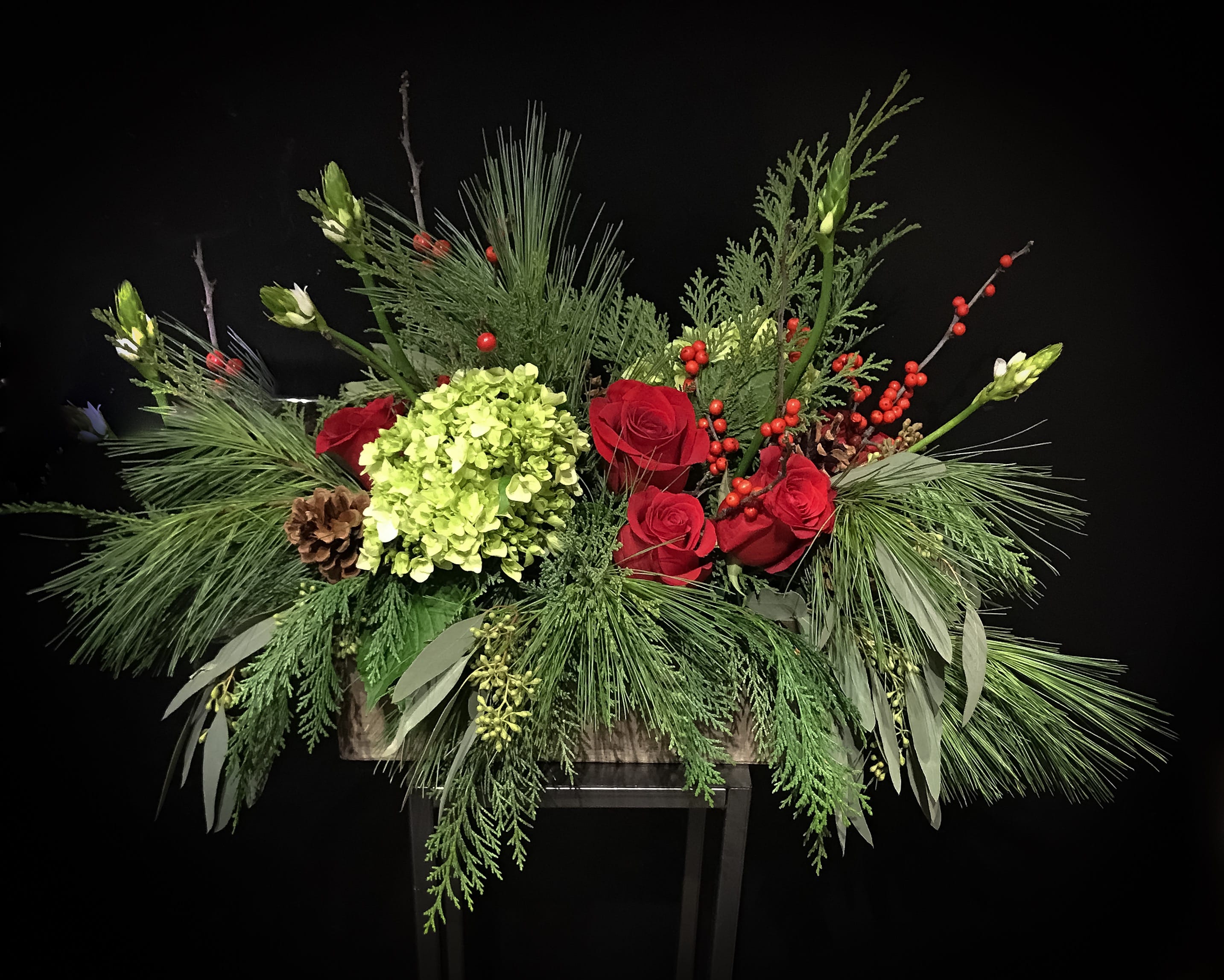 Holiday Joy - Introducing Holiday Joy...  Woodsy gatherings of evergreen, pine cones, berries and vibrant red roses to hail a happy holiday!  All designed in a wooden box making a wonderful choice for gift giving or a holiday centerpiece.