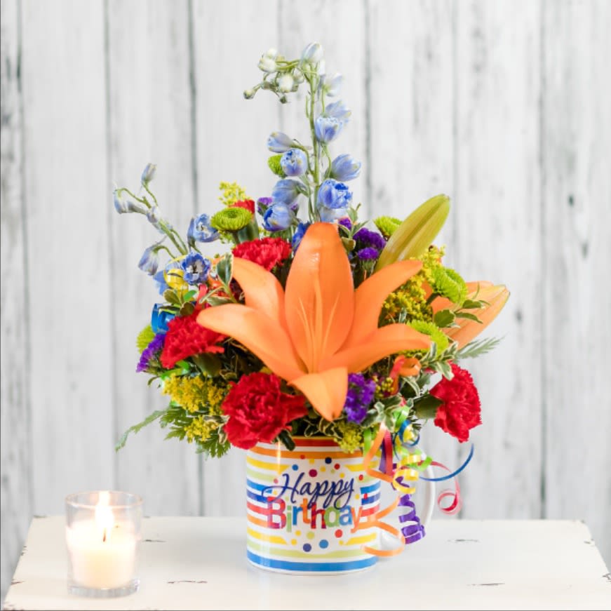 Surprise - Celebrate with a bright birthday arrangement in a reusable mug!  Colored streamers add a festive accent!  Approximate Dimensions: 9&quot; W x 14&quot; H