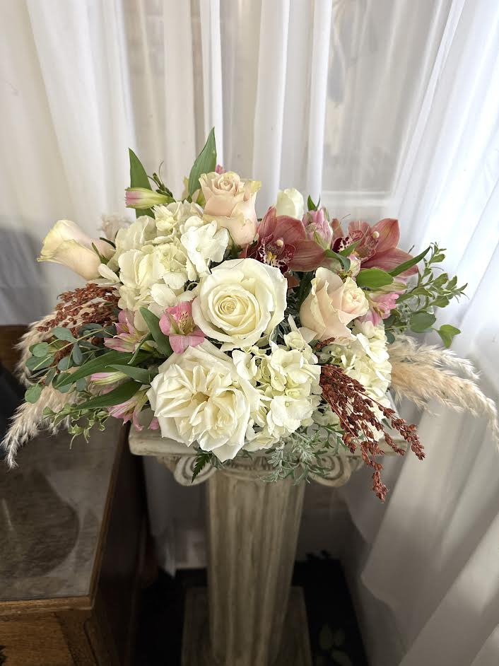 White Christmas - A white bowl is filled with white, pale pink, peach, and earth-tone flowers and textural elements.  