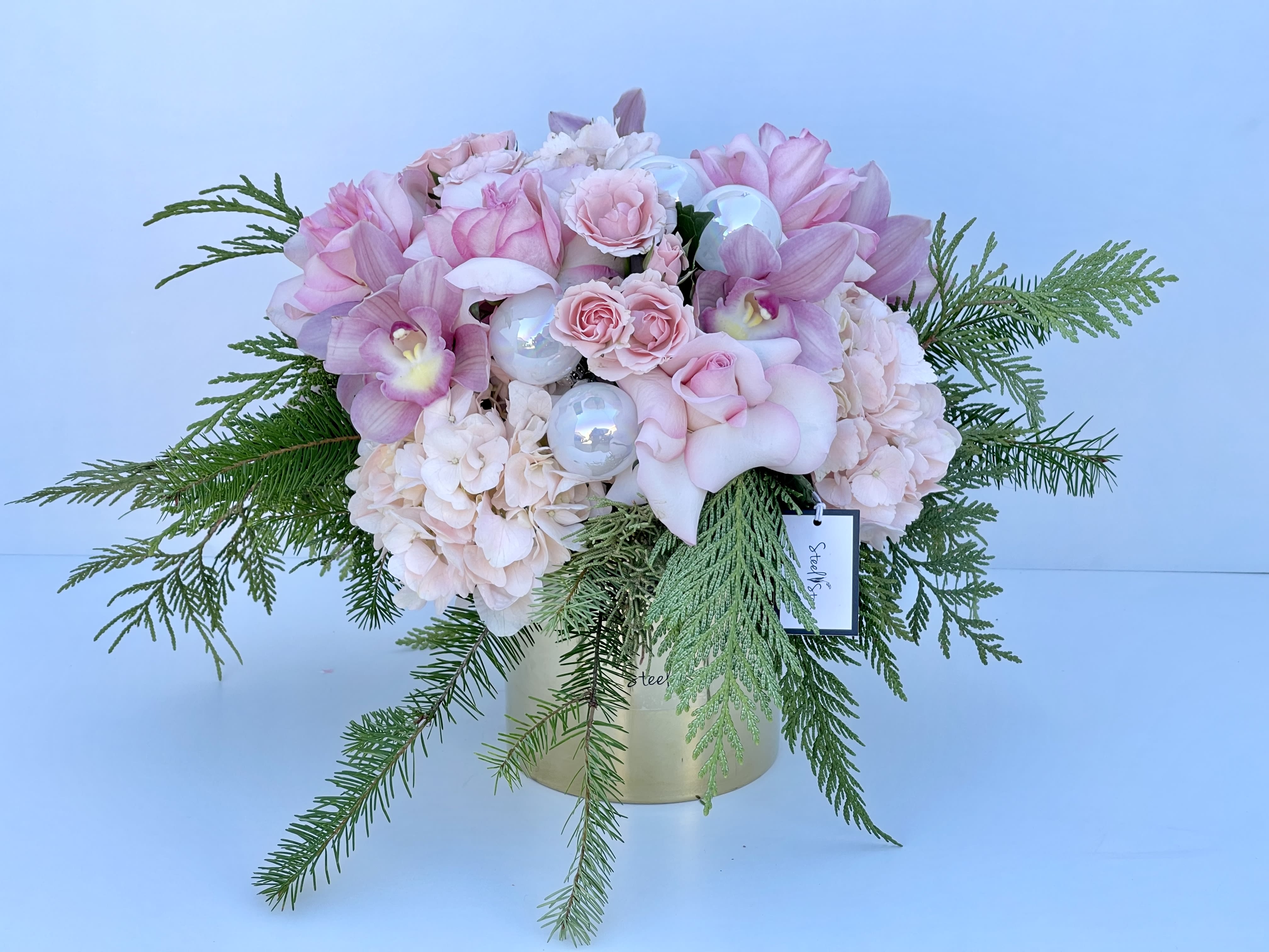 Sweet Holiday - Happy Holidays! Say it with our monochromatic pink Sweet Christmas arrangement. Made of fresh Christmas Greens, premium Orchids, pink roses, pink spray roses, pink hydrangeas, white ornaments and a high quality gold vase. It's a perfect statement piece for a gift or your self.