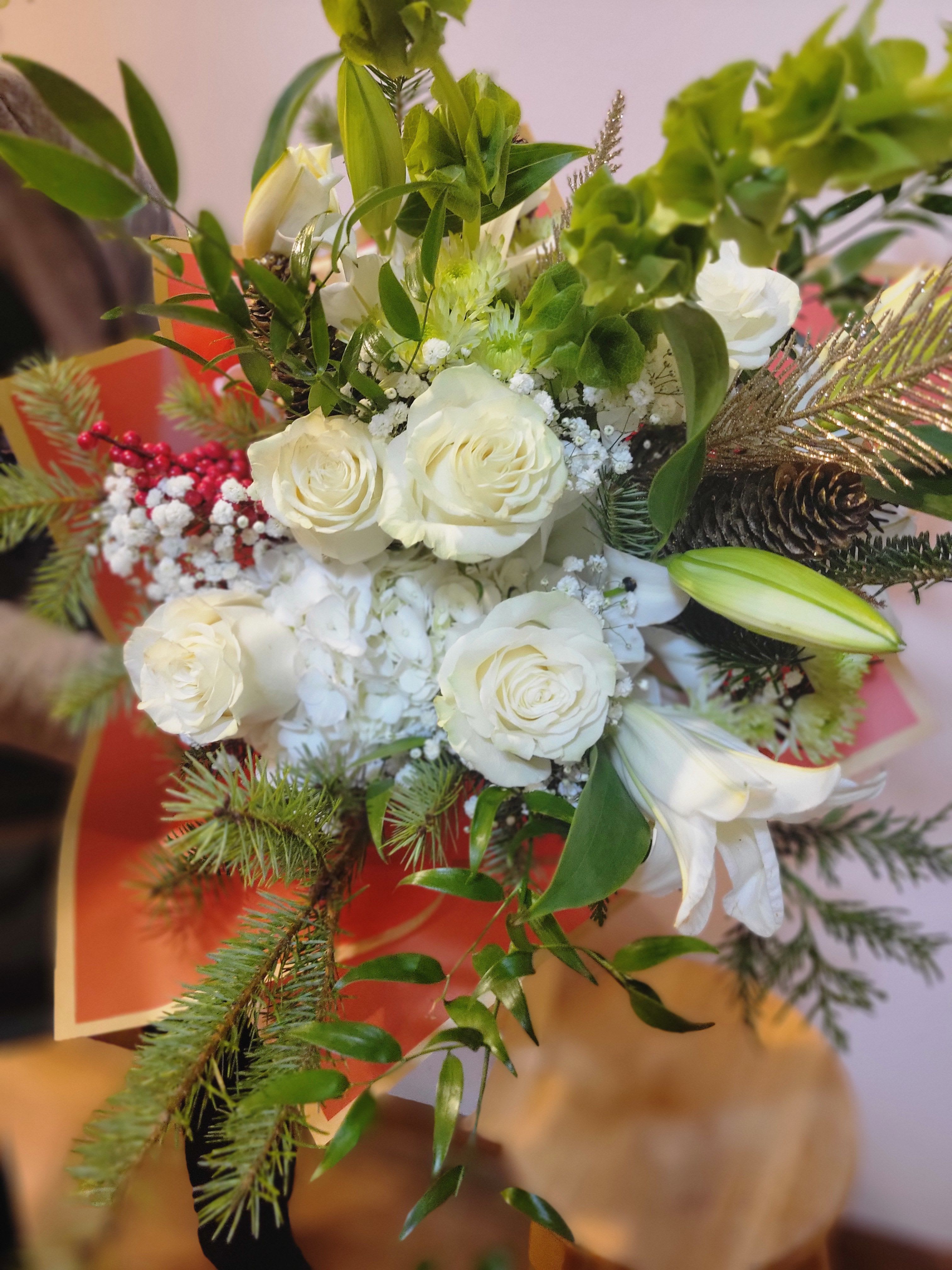 Hand Tied Bouquet - A fresh, elegant bouquet with soft whites and greens, accented by natural textures and warm seasonal touches. Beautifully arranged for a clean, festive, and timeless look.