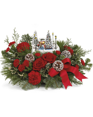 Thomas Kinkade's Oh What Fun Centerpiece  - Celebrate the season with this delightful Thomas Kinkade collectible, nestled among festive red roses and winter greens-a memorable gift that lights up with a classic ice skating scene for extra holiday joy. Celebrate the holidays with Thomas Kinkade's Oh What Fun arrangement. It includes vibrant red roses, classic red carnations, and miniature red carnations, accented with variegated holly, noble fir, white pine, and cedar.  It makes a festive seasonal centerpiece. Orientation: All-Around 