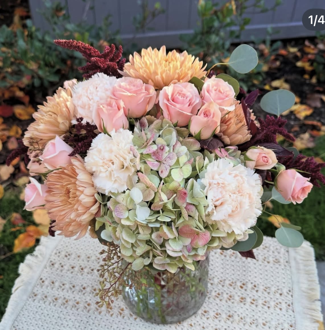 Florence  - Elegant flowers that evoke joy, beauty and happiness. This beautiful design created with premium flowers in warm colors. Beautiful roses, chrysanthemums, fancy carnations, seasonal eucalyptus, antique hydrangeas and fresh burgundy amaranthus. It includes a glass vase Medium size  Share joy share flowers 