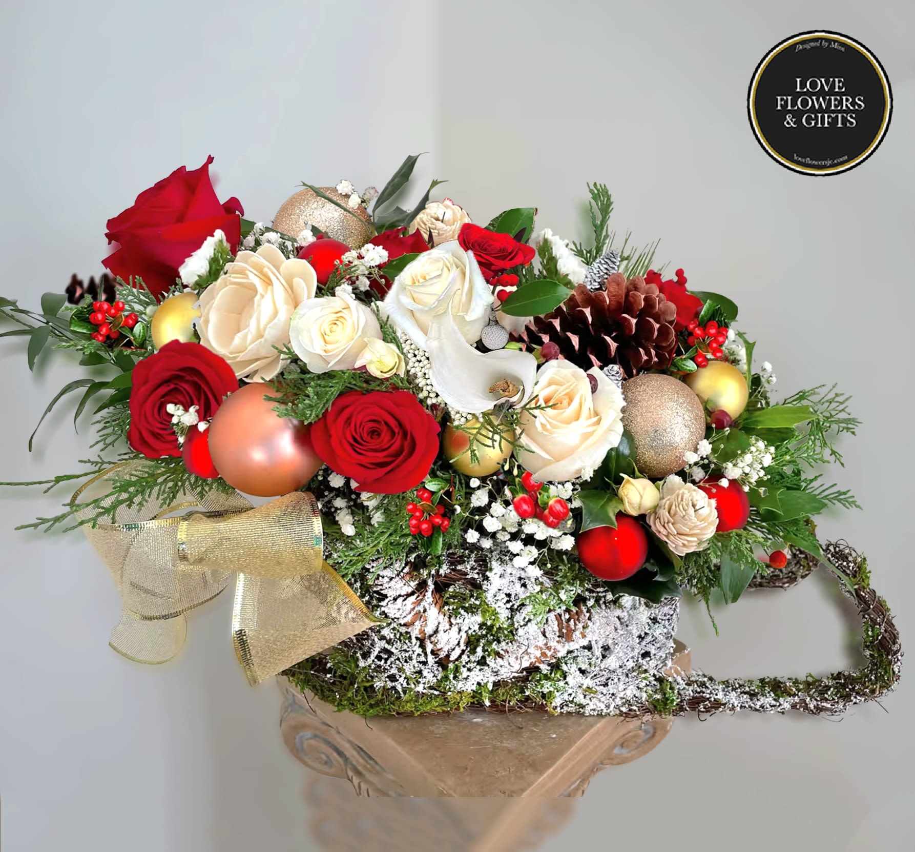 Sleighing Down  - A unique christmas centerpiece designed in a sleigh shape moss nest-style container with seasonal color blooms and textures with christmas decors in a bed of fresh greenery. 