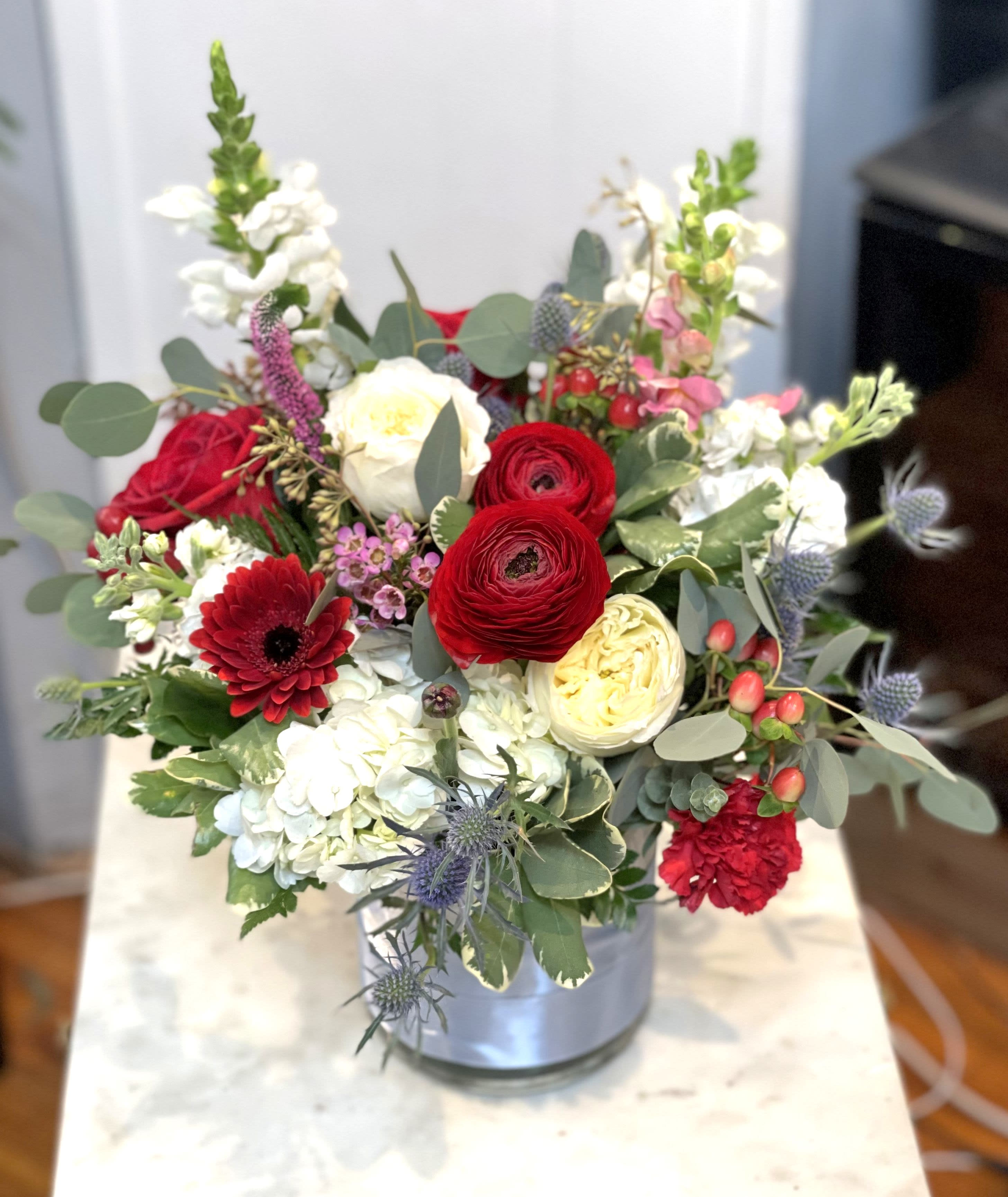 Newport - Beautiful design with simplicity in striking red and white, with hint of blue and grey. Featuring ranunculus, rose, hydrangea, thistle, garden roses. 