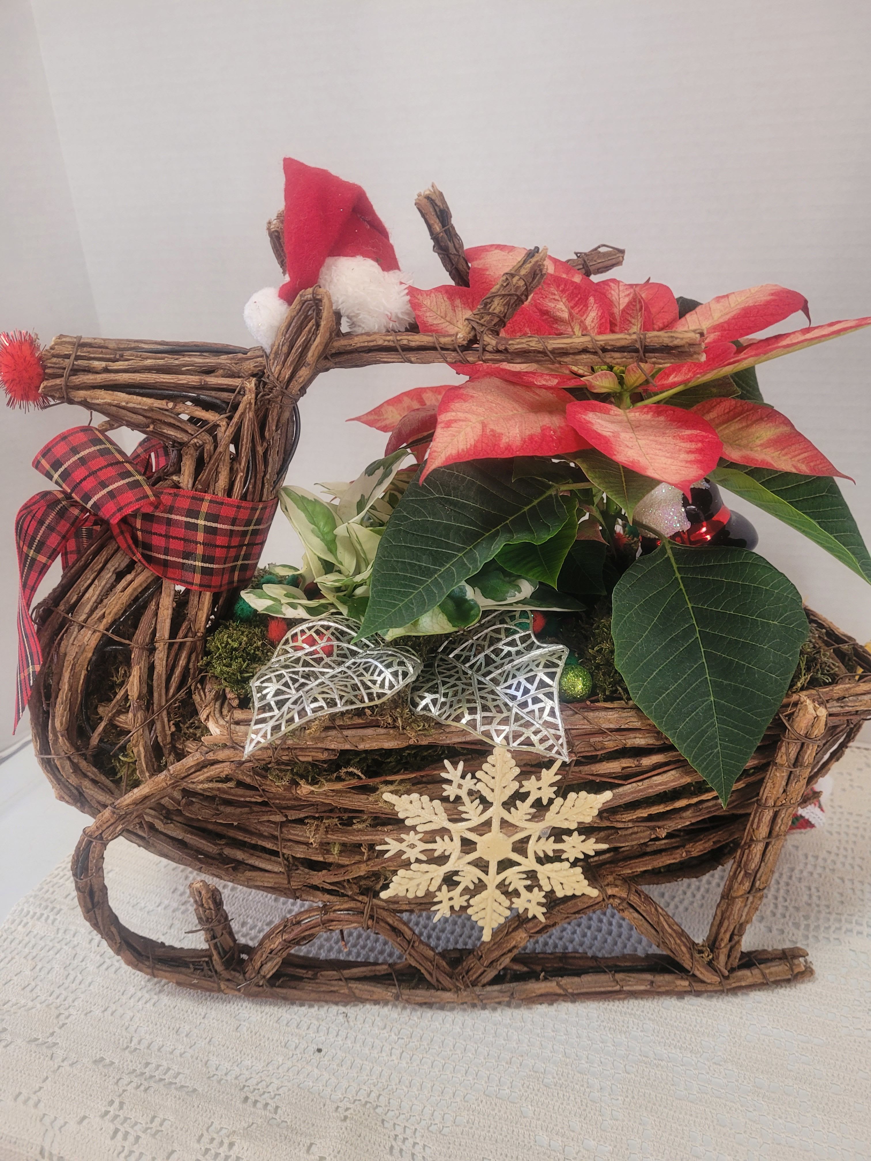 Reindeer #1 - A festive wicker reindeer featuring holiday colors and lots of faux embellishments. This arrangement will add a touch of whimsy to any table 