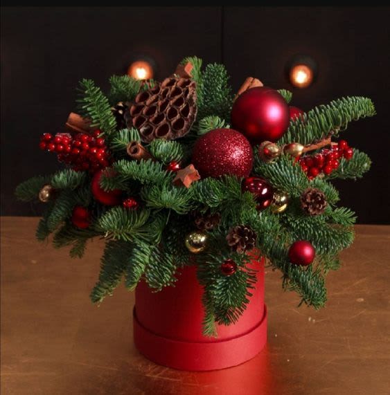 Winter Nigth - Fresh flower arrangement featuring pine and seasonal ornaments. Some items may be substituted depending on availability.
