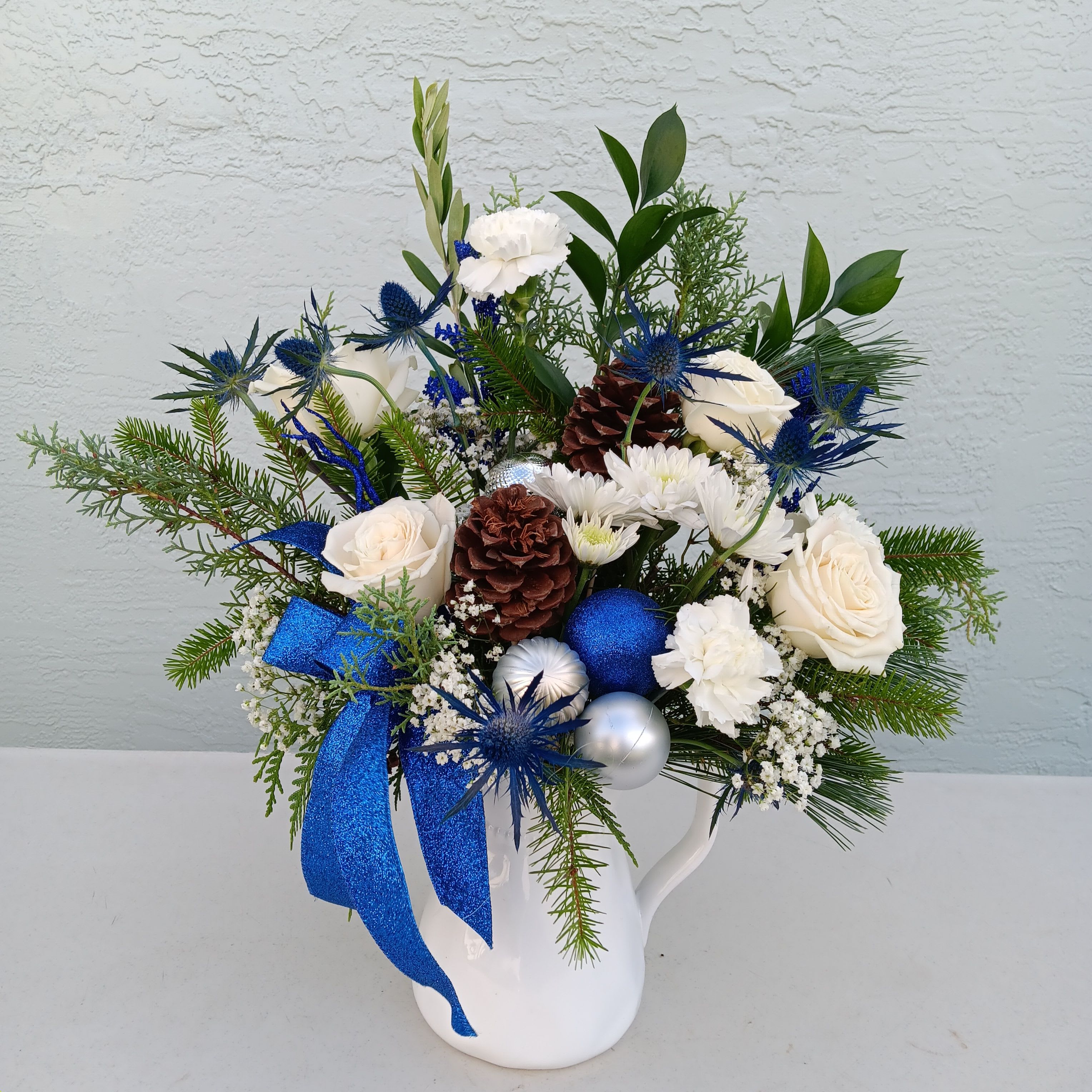 Winter breeze - Holiday bouquet in white, blue and silver theme arrives in white ceramic pitcher