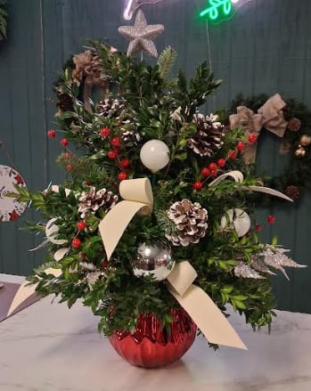 Winter Wonderland Tree - Transform any space into a festive escape with our enchanting Winter Wonderland Tree. Hand-crafted with fresh, fragrant boxwood, this petite Christmas tree is adorned with sparkling holiday embellishments, shimmering accents, and whimsical winter touches that bring the season to life. Perfect for apartments, offices, dorms, or cozy corners at home, this long-lasting design delivers all the magic of a Christmas tree in a compact, easy-to-enjoy size. A charming gift or a delightful décor piece, it’s the perfect way to add a touch of winter wonder to any space.