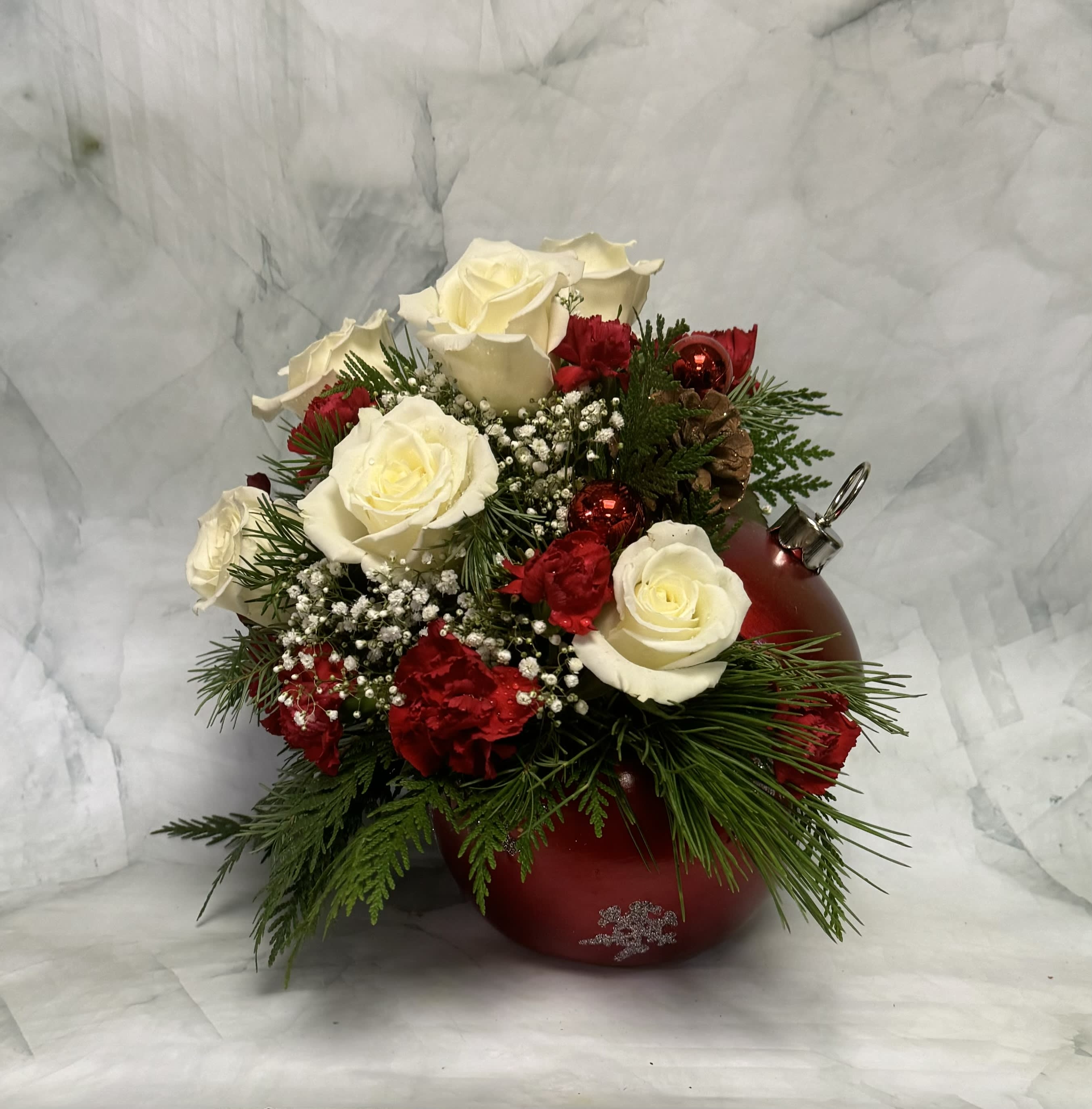 Sparkling Snowflake Ornament - This arrangement doesn't just shine, it sparkles! Send this enchanting design to someone you love this holiday season. This arrangement includes white Roses, red Mini Carnations, Babies Breath, winter greens and some holiday decorations.