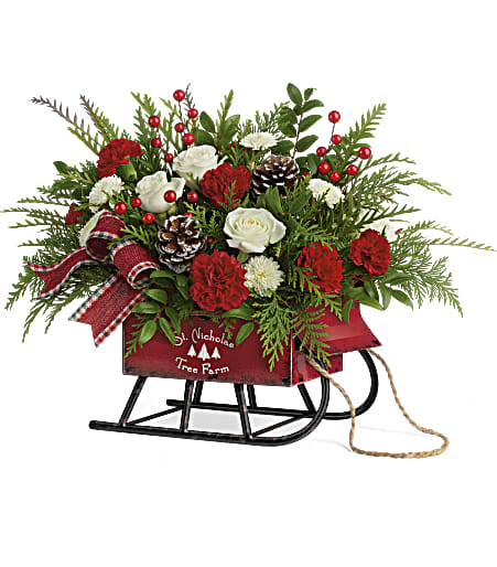 Teleflora's Sleigh Bells Bouquet - Sleighbells ring! Sliding into the season in a vintage metal sleigh with rustic antique finish and pull rope, this lush mix of snow-white roses and winter greens delivers classic Christmas style! 