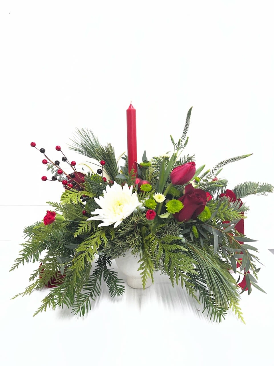 Calm &amp; Bright - Calm &amp; Bright  Warm and inviting Christmas centerpiece designed to bring a gentle glow to any holiday setting. Nestled in a soft cream low vessel, this arrangement blends rich seasonal reds with crisp winter whites. Lush red roses, red tulips, and red carnations create a vibrant, festive heart, while white mums add a touch of brightness and balance. Textured winter greenery weaves throughout, offering depth, fragrance, and a natural, wintry charm. Perfect for tabletops or intimate gatherings, Calm &amp; Bright captures the serene beauty of the season with a modern, elegant touch.