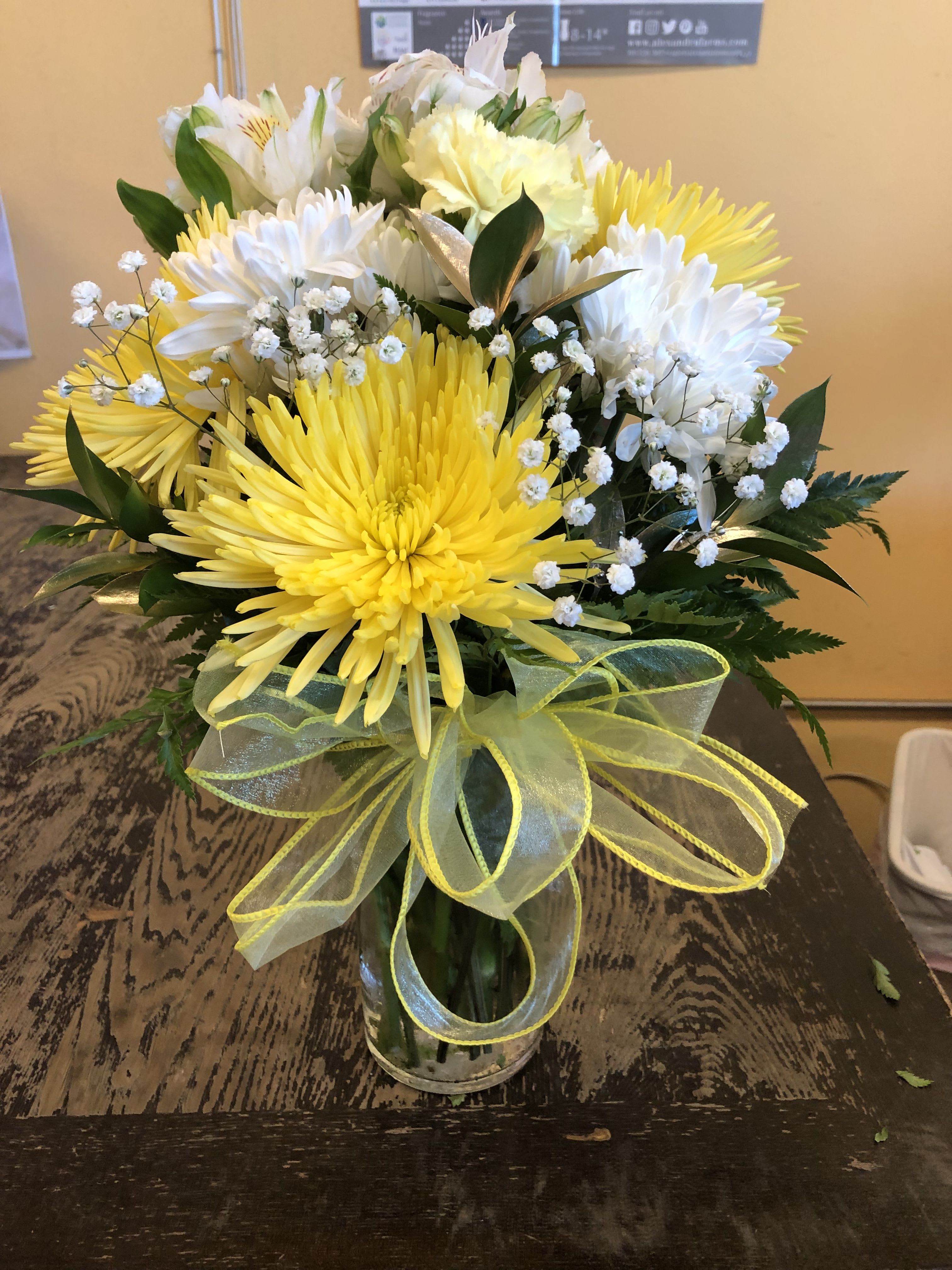 YELLOW AND WHITE VASE ARRANGEMENT (DESIGNER CHOICE) - NOTE: NO ROSES ARE INCLUDED IN THIS ARRANGEMENT  ITS ABOUT 12 INCHES TALL, THIS ARRANGEMENT WILL INCLUDE A MIXTURE OF CARNATIONS, ALSTROMERIA, CUSHION AND SPIDERS, WITH FILLERS TO BE BABY BREATH AND GOLD OR SILVER RUSCUS STANDARD SIZE IS A PICTURED DELUXE AND PREMIUM WILL BE IN A BIGGER VASES WITH MORE OF THE MENTION FLOWERS REMINDER NO ROSES ARE INCLUDED IN ANY OF THE UPGRADES