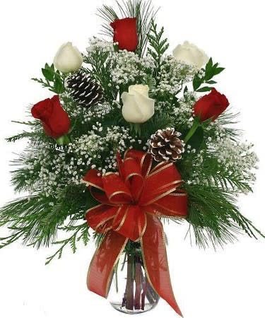 A Christmas Rose Vase - Red and white roses make a dashing holiday gift, especially when they are arranged with brilliant holiday touches and delivered in a clear vase with Christmas trim.