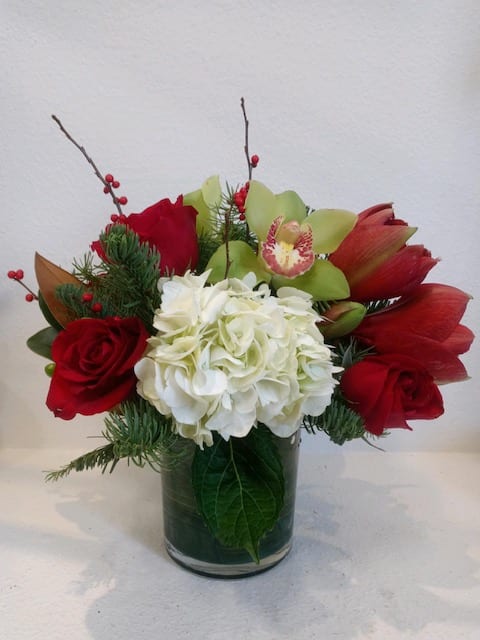 Seasons Greetings - A gorgeous assortment of Red, White and Green Flowers. Lux Amaryllis, Roses, Orchids and Hydrangea all together in one vase. A perfect gift for a special person.