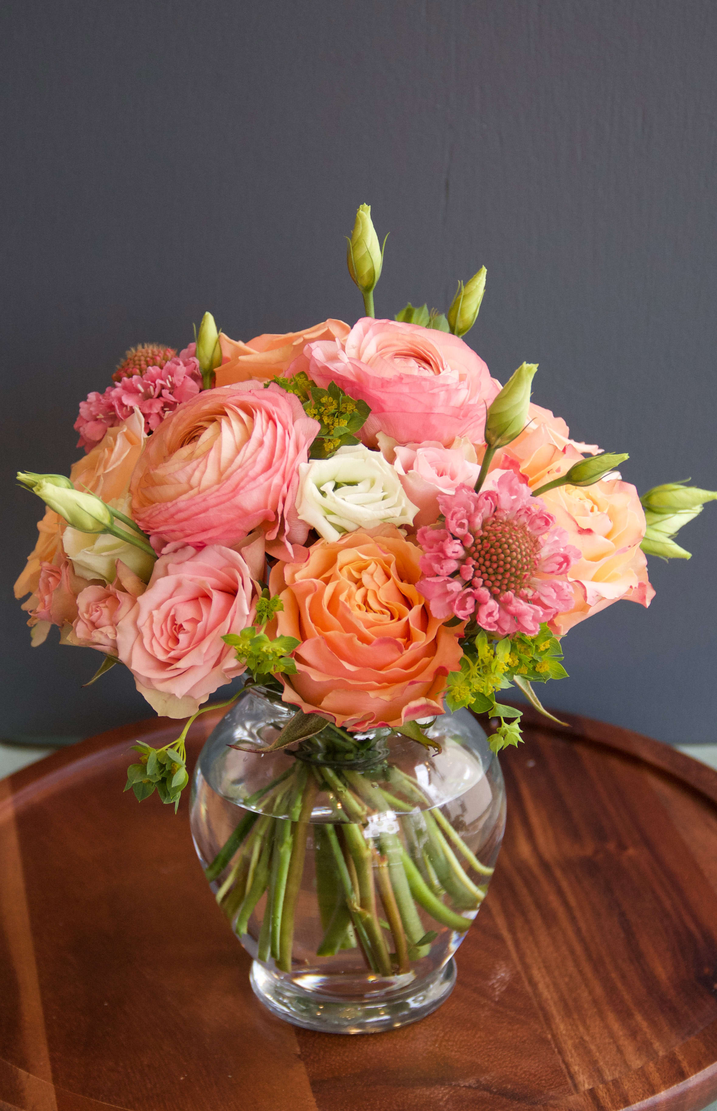 Peach Perfection - A lovely peach arrangement with a monochromatic peachy pink color scheme. This adorable posey is perfect for a coffee table or night stand. Minimal greens and a lovely selection of premium flowers are closely packed into this joyful arrangement.