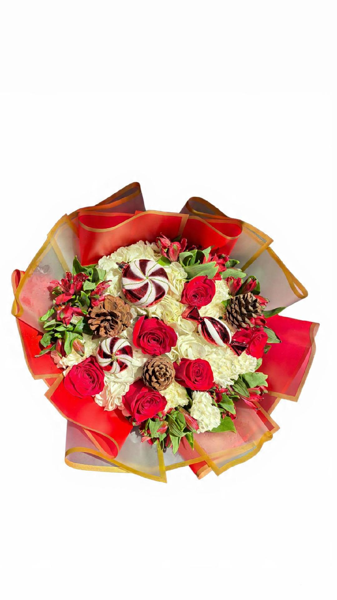 Peppermint Holiday Bouquet - Celebrate the season with this stunning holiday bouquet featuring red roses, creamy white blooms, festive greenery, pinecones, and peppermint-inspired ornaments. Wrapped in vibrant red and gold, it’s the perfect gift to brighten any Christmas celebration.