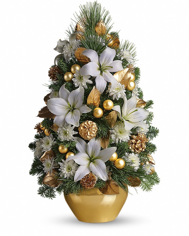 Celebration Tree - Here's a beautiful boost to the spirit of the season. Gorgeous blossoms ornaments and greens are shaped to look like a Christmas tree - it's fabulously unique! Pretty white spray roses asiatic lilies and cushion spray chrysanthemums are artfully arranged with gold ornaments white pine and Douglas fir. A delightful gold jardinière container completes this wonderful picture.Approximately 15" W x 24" H