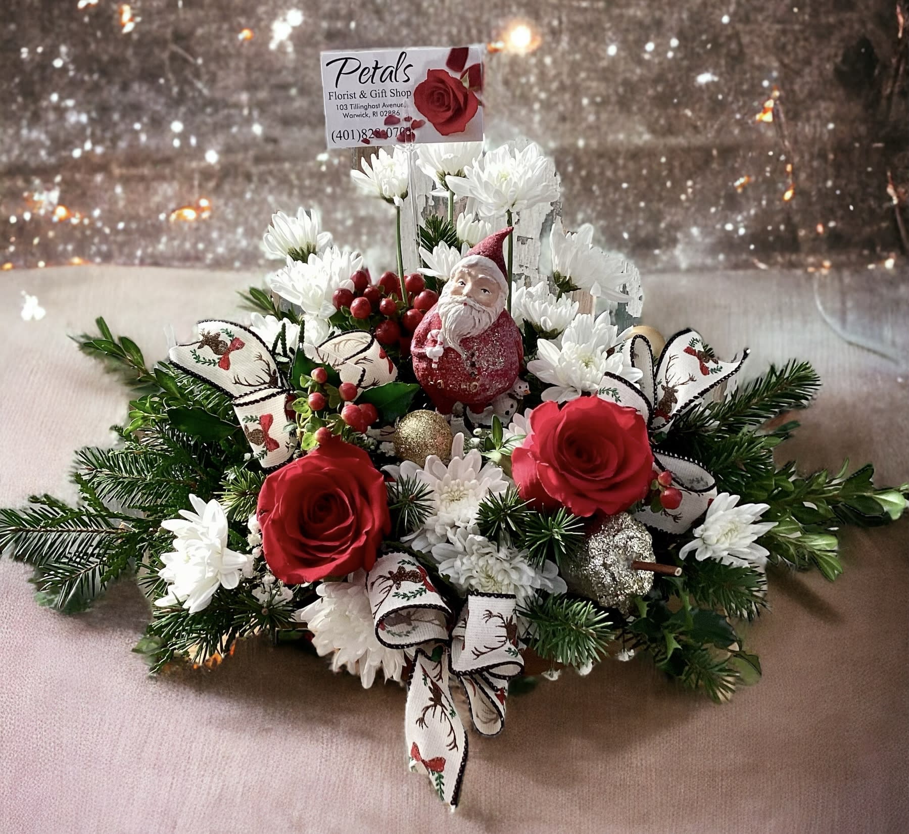 Ho Ho Ho Santa Centerpiece by petals - This cheerful Ho Ho Ho Santa Centerpiece will surely put a smile on the face of your recipient. It's a gift within a gift as well, they will enjoy the little Santa as a holiday keepsake for years to come. Designed with a fragrant assortment of winter greens, chrysanthemums, red roses, red hypericum berries, pinecones, boss and balls. * Bows will vary in color and patterns—limited quantity for this Santa figure. Please call me at 401-828-0701 if you have any questions. Thank you, Cheryl