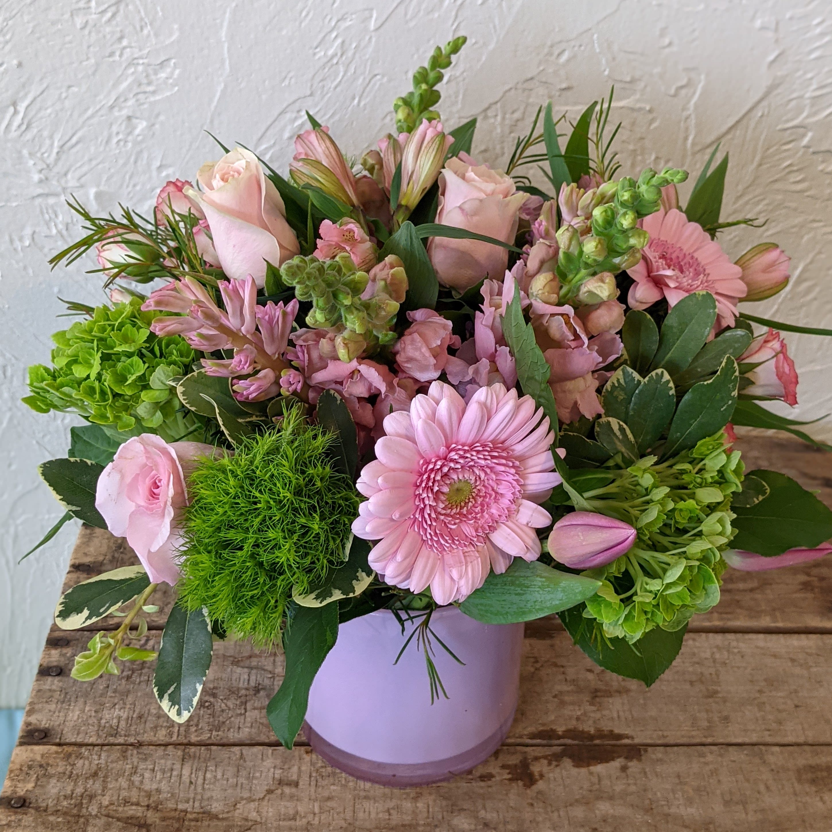 Monochrome Designer's Choice - Pink - Pick the color and leave the flowers up to us with our Monochrome series Designer's Choice flower arrangements. These pieces feature a primary color pallet which we will design a beautiful arrangement of flowers around. Some accent colors may be used but the primary color scheme will designed with your chosen color in mind (Color listed in the name of this piece)    *Vase color and style may vary. Please note that the arrangement displayed in the picture is an example piece and flowers featured are not guaranteed to be replicated