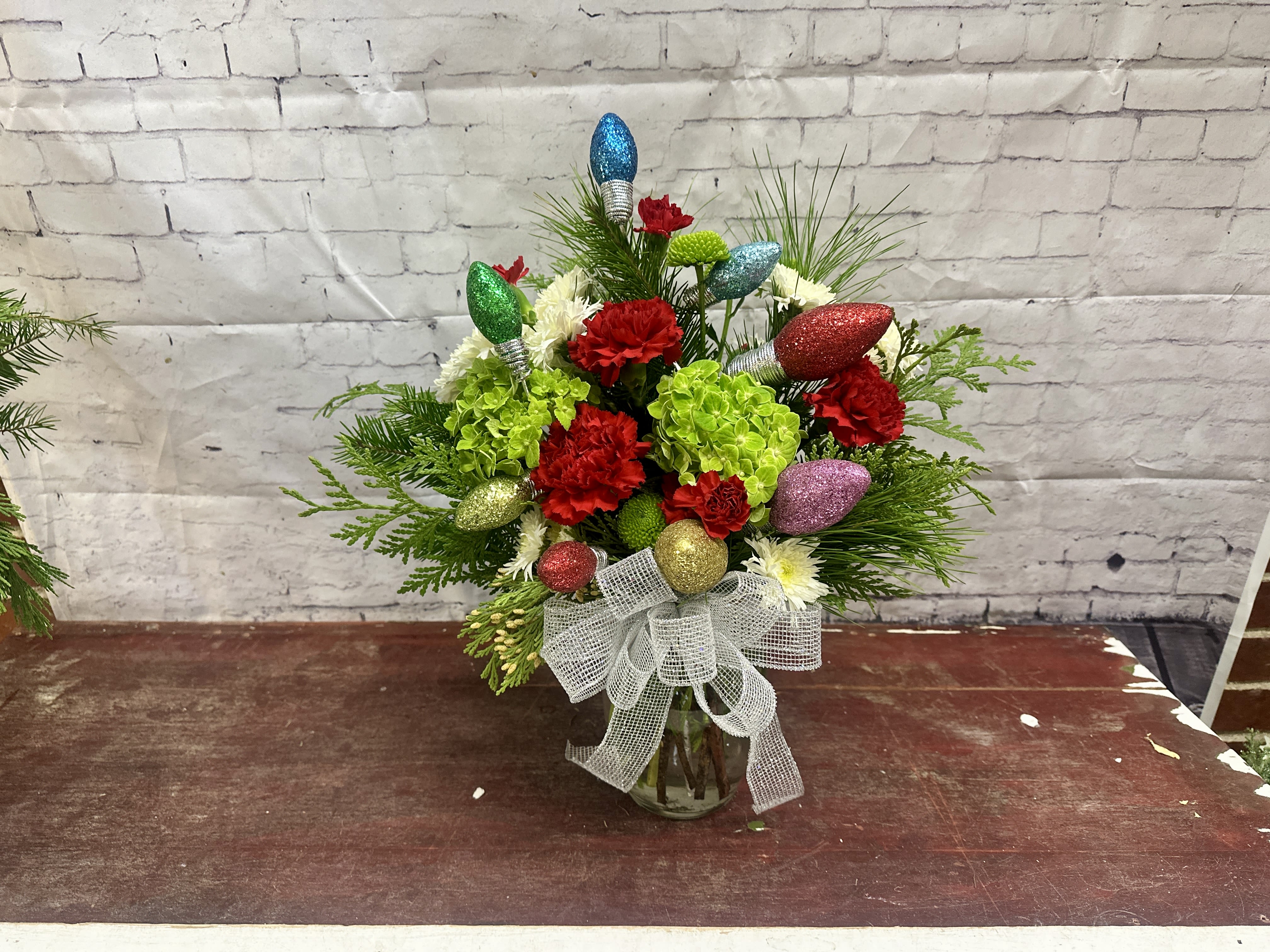 Holiday sparkle  - Bright colored Christmas flowers adorned with festive sparkly Christmas lights 