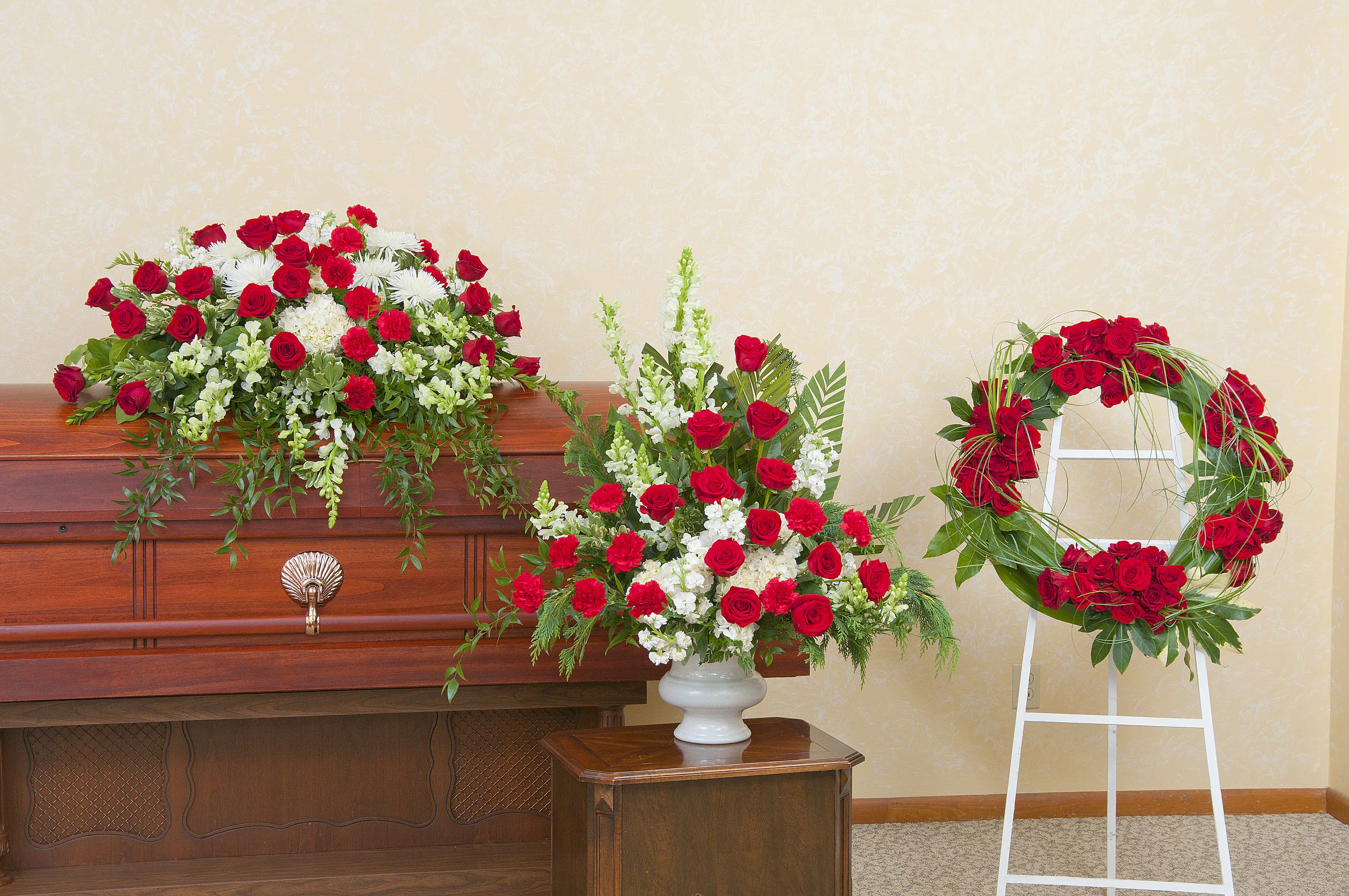 classic setting for funeral - Red and white trio casket spray, urn and wreath. 