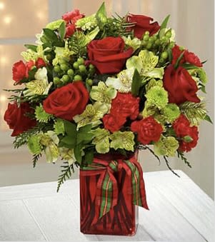 Yuletide Joys Bouquet - Rich reds and greens greet the eye with this merry Yuletide Joys Bouquet!  Red roses, green buttons, alstromeria, green berries and festive greens abound in this glimmering arrangement.