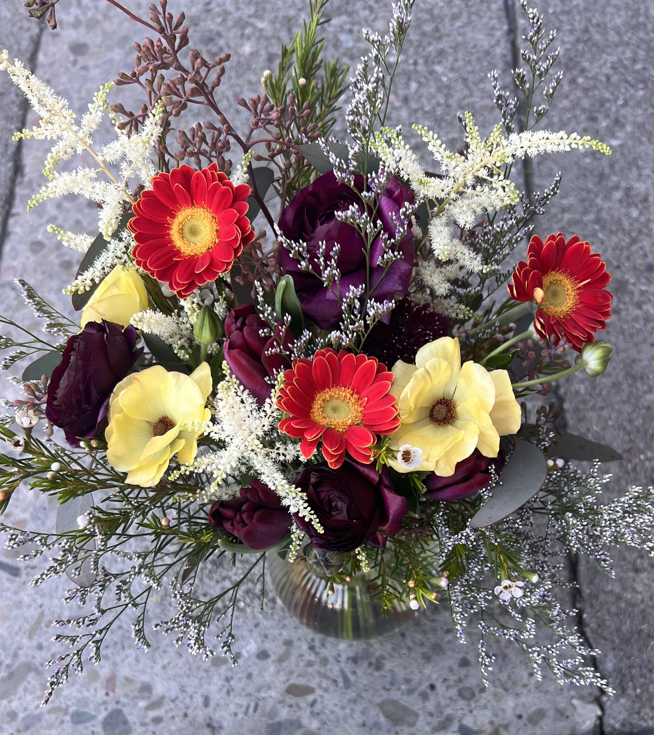 Whispering Symphony - A dreamy composition where velvety purples meet radiant golds and scarlet tones. Ethereal white sprays dance among the blooms, evoking the gentle hush of a wild meadow touched by morning light.