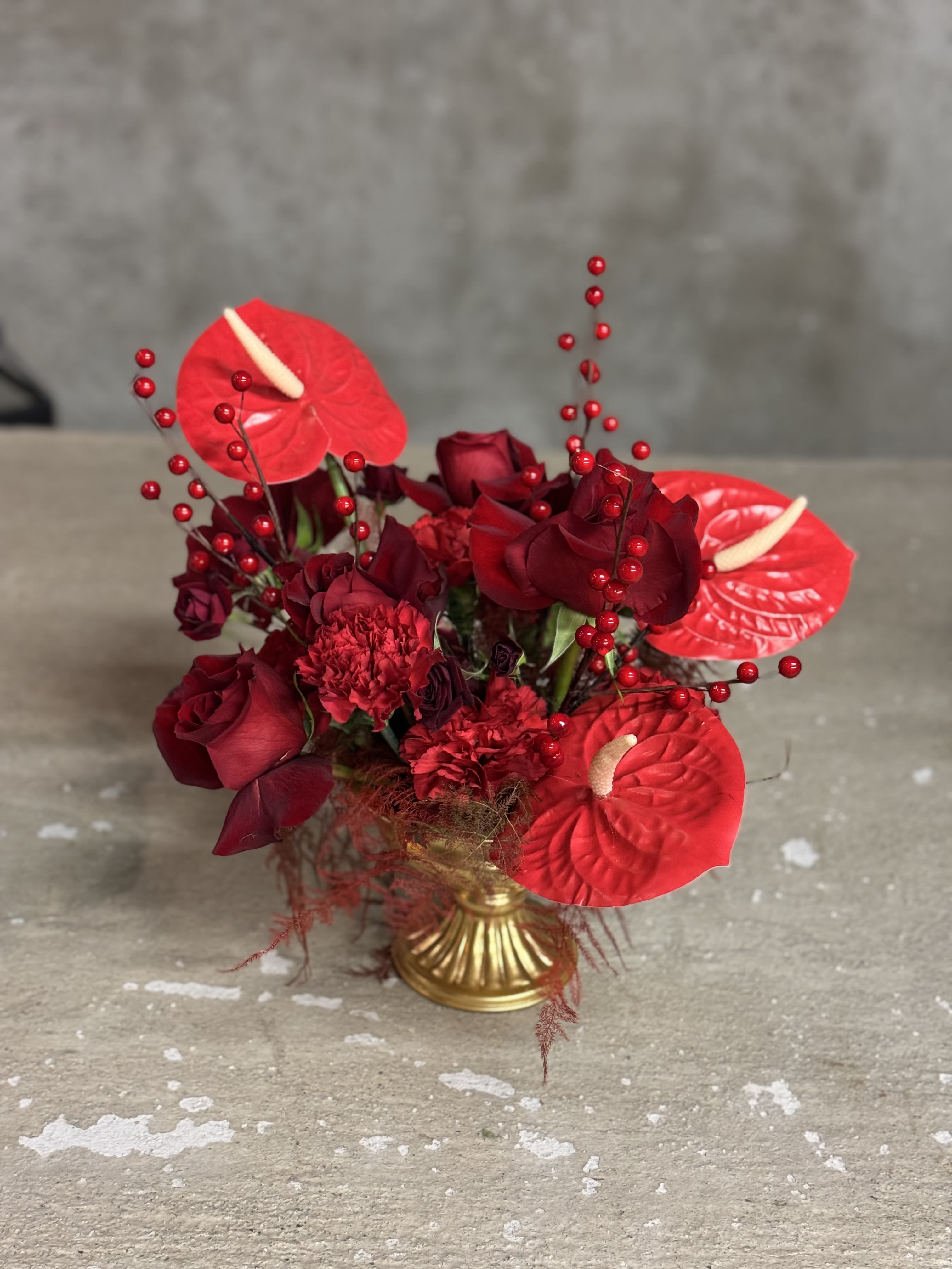 Winter In Vogue - Contemporary monochromatic Christmas arrangements for your table scape. Beautiful mix of red and burgundies.   Please note, this piece contains fresh and silk flowers. 