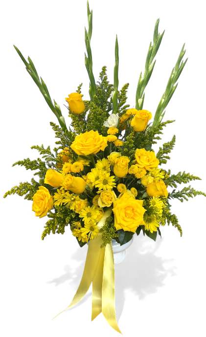 Bright Blessings Footed Urn Arrangement - The Bright Blessings footed urn arrangement radiates warmth and hope with its vibrant yellow blooms gracefully accented by lush greenery. Artfully designed to evoke a sense of comfort and remembrance, it features a harmonious blend of roses, lilies, and seasonal florals that symbolize friendship, optimism, and everlasting love.  The elegant urn base adds a touch of classic sophistication, making this arrangement a beautiful focal point for any memorial service.  Offering a heartfelt tribute, it celebrates cherished memories and brings a gentle brightness to honor a life well-lived.
