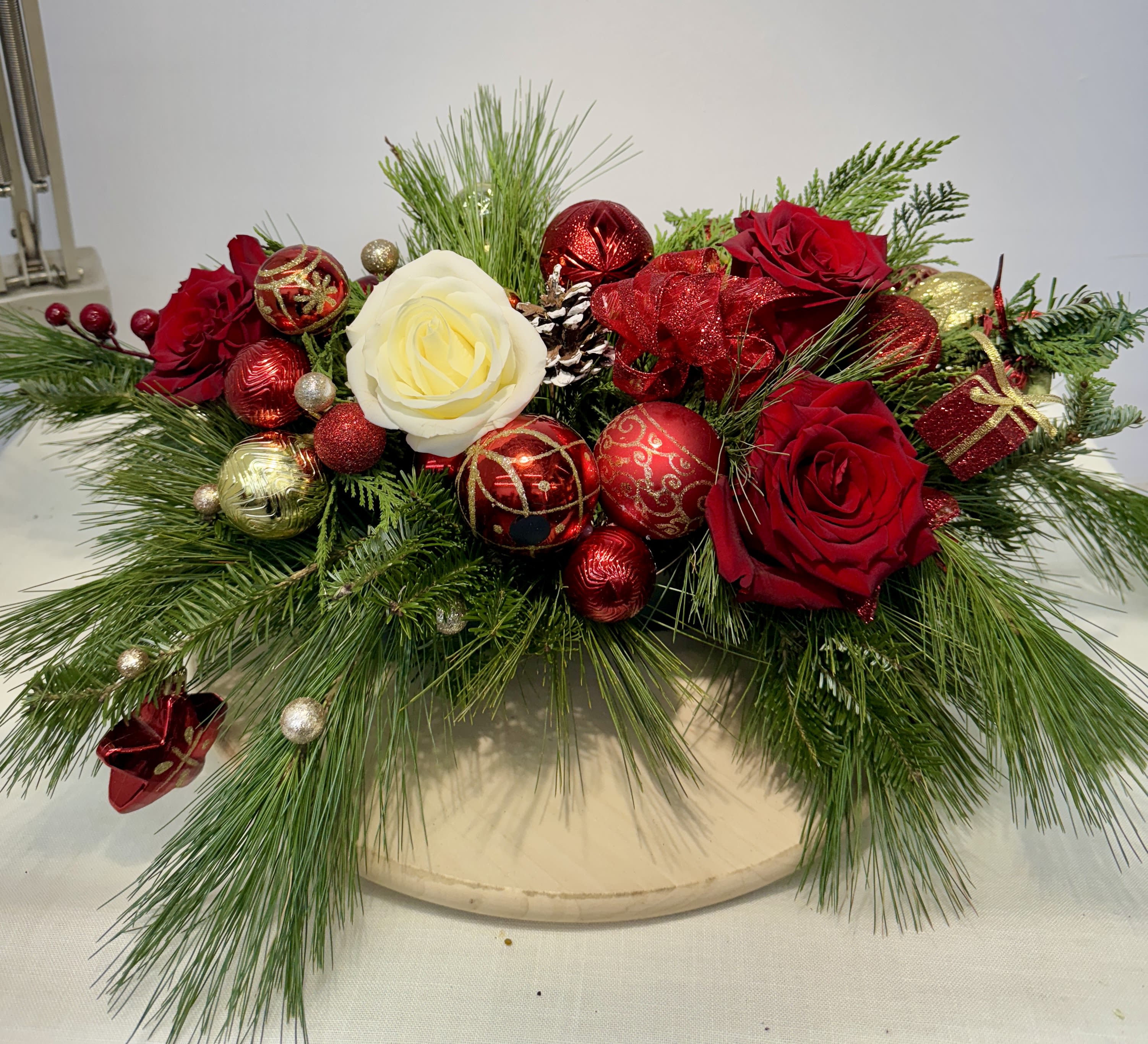 Christmas Centerpieces. - Bring the spirit of the holiday season indoors with this beautiful arrangement. The beautiful red roses and carnations pair gorgeously with the sprigs of pine, pheasant feathers, and pine cones to create a simply stunning rustic mix and ornamental.