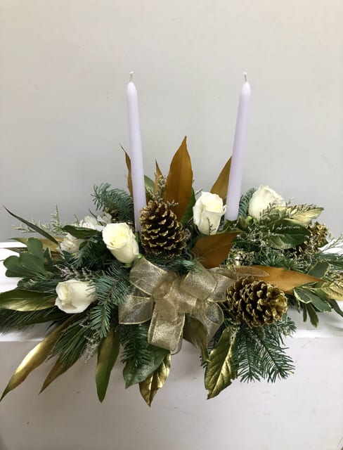 Golden Light - Two tapered white candle in a green and gold setting with white roses and  pine cones and gold leaves and bow