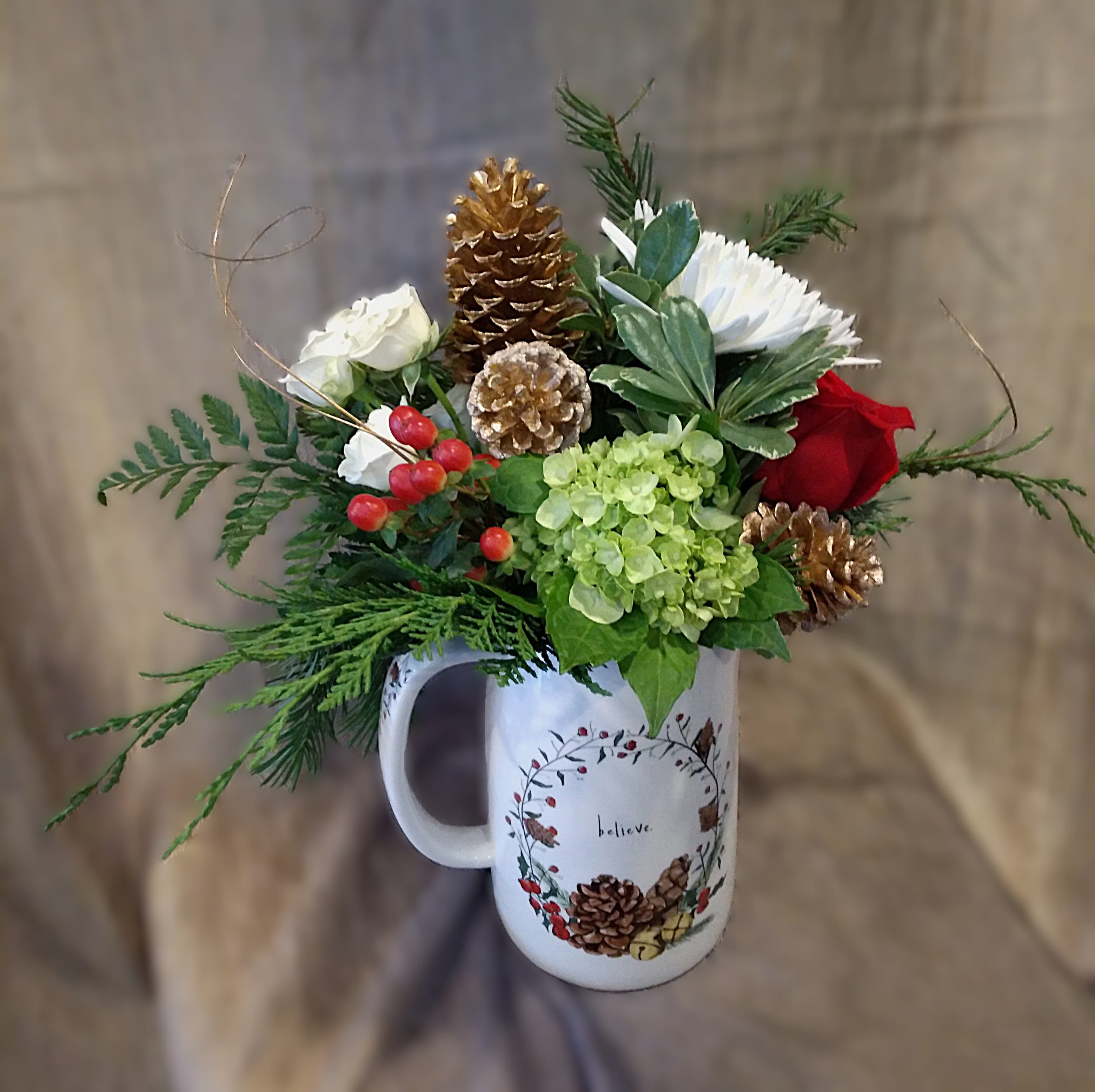 Yuletide Charm Pitcher - Yuletide Charm brings festive elegance to any holiday home. Perfect for gifting or gracing your own table, it features a white ceramic pitcher, lush seasonal blooms and gold accents.