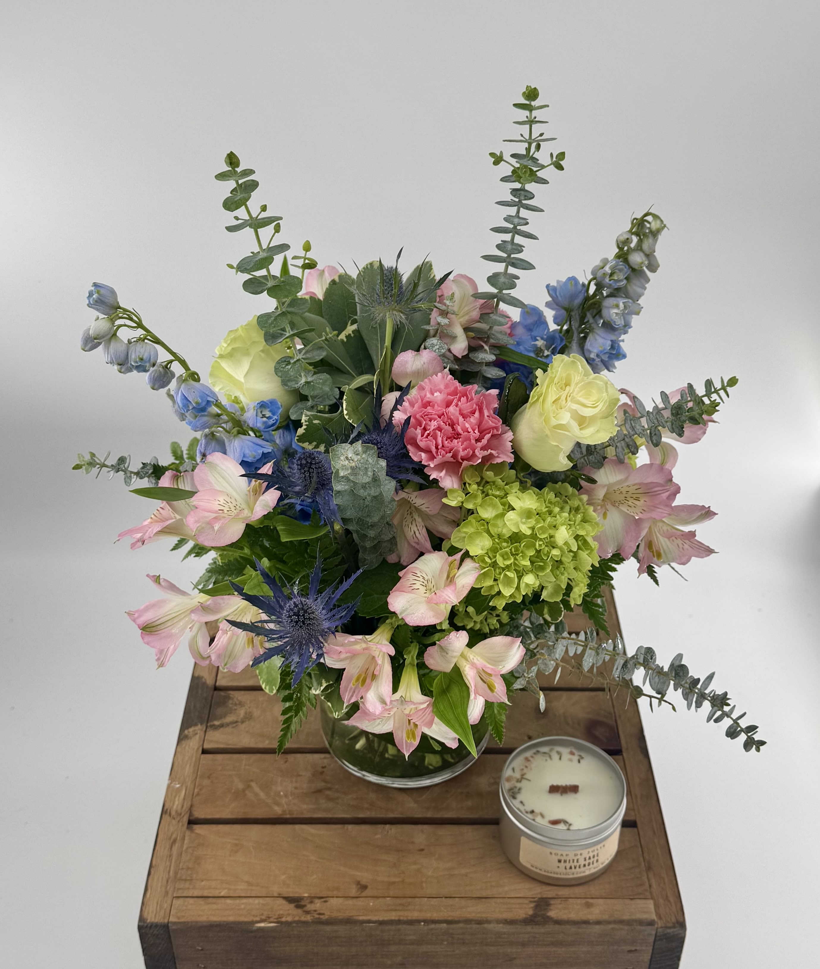 Breathtaking Blossoms  (DL) - You’d like to surprise someone with gorgeous fresh flowers…a mix of blooms that looks as if the entire garden has been put into a vase! This splendid medley of blue, cream, white, pink and lavender flowers, presented on a bed of river rocks, is a beautiful choice. Approx 12"- 15" H