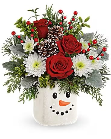 Smiling Snowman Bouquet - Send a snow-day full of Christmas delight with this joyful red rose bouquet, charmingly arranged in a sweet ceramic snowman with sparkling glitter finish! This sweet bouquet features red roses, white cushion spray chrysanthemums, white pine, cedar, oregonia and dusty miller. Delivered in a Festive Frosty Cube.