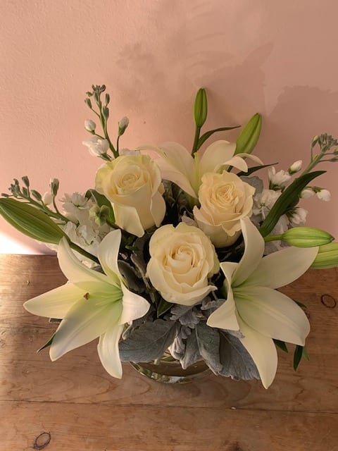 All white lilies, roses, stocks - w580 - Like a vacation for the senses this lovely bouquet delivers an oasis of beauty and elegance. Soothing serene and very special. White roses white  lilies and stock stem are incredibly arranged in a glass vase. When it comes to bouquets this is definitely the right way to do white.Approximately 14" W x 11 1/2" H Orientation: All-Around As Shown. W580