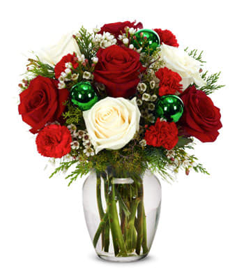 Cheerful Christmas  - White roses, red roses, red mini carnations and white waxflower are complemented by vivid Christmas ornaments and a clear fluted vase in this arrangement that conveys the merry sentiments of the season in a traditional yet memorable way. Measures 12"H by 10"L.