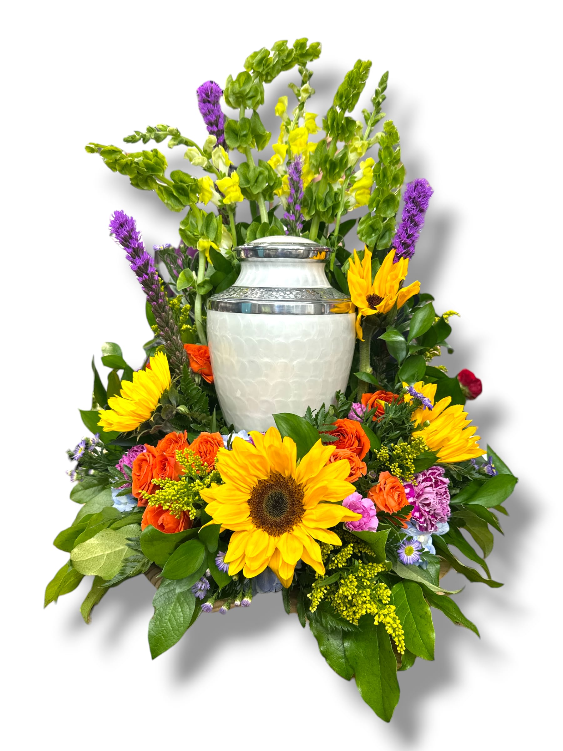 Vibrant Life Round Urn Surround - This vibrant floral arrangement features a cheerful mix of sunflowers, orange roses, purple asters, yellow snapdragons, and other colorful blooms, all beautifully accented with lush green foliage. The combination of bold and soft colors creates a warm, inviting, and celebratory atmosphere, perfect for honoring a special occasion or expressing heartfelt sentiments.  The urn is not included.